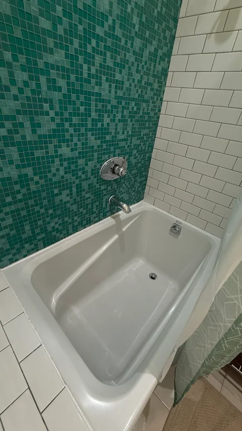 Freshly cleaned bathtub with mosaic tile